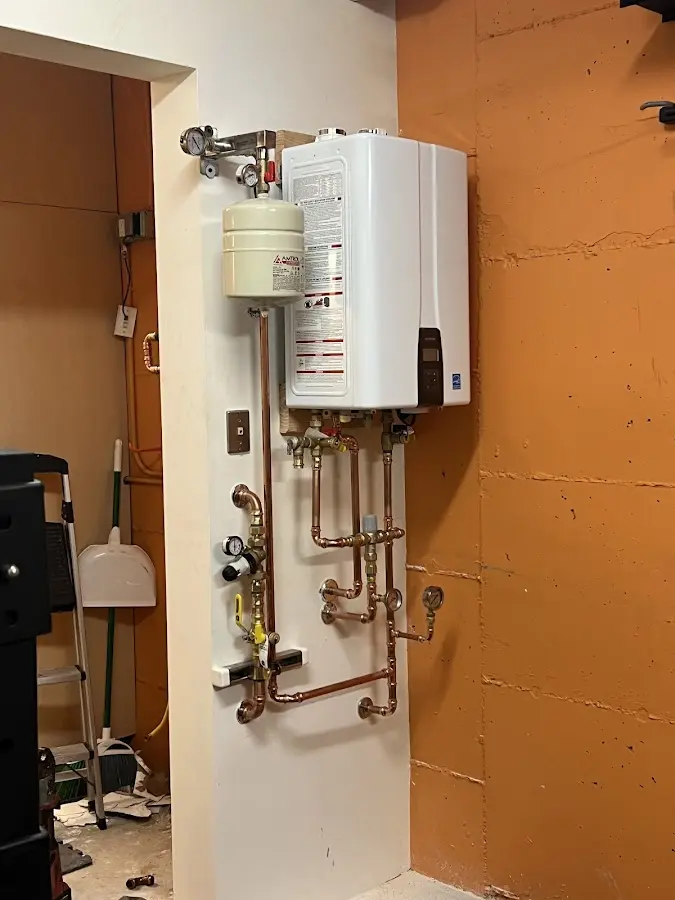 Plumbing technician inspecting water heater connections in Waconia